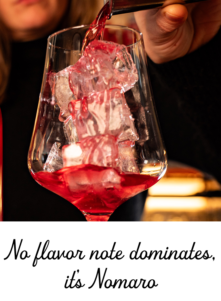 Red liquid being poured into a glass with ice cubes, with text 'No flavor note dominates, it's Nomaro' at the bottom.